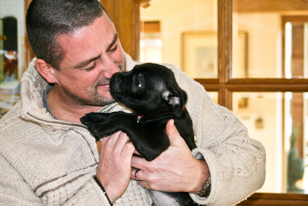 a man cuddling his new puppy and teaching him life skills